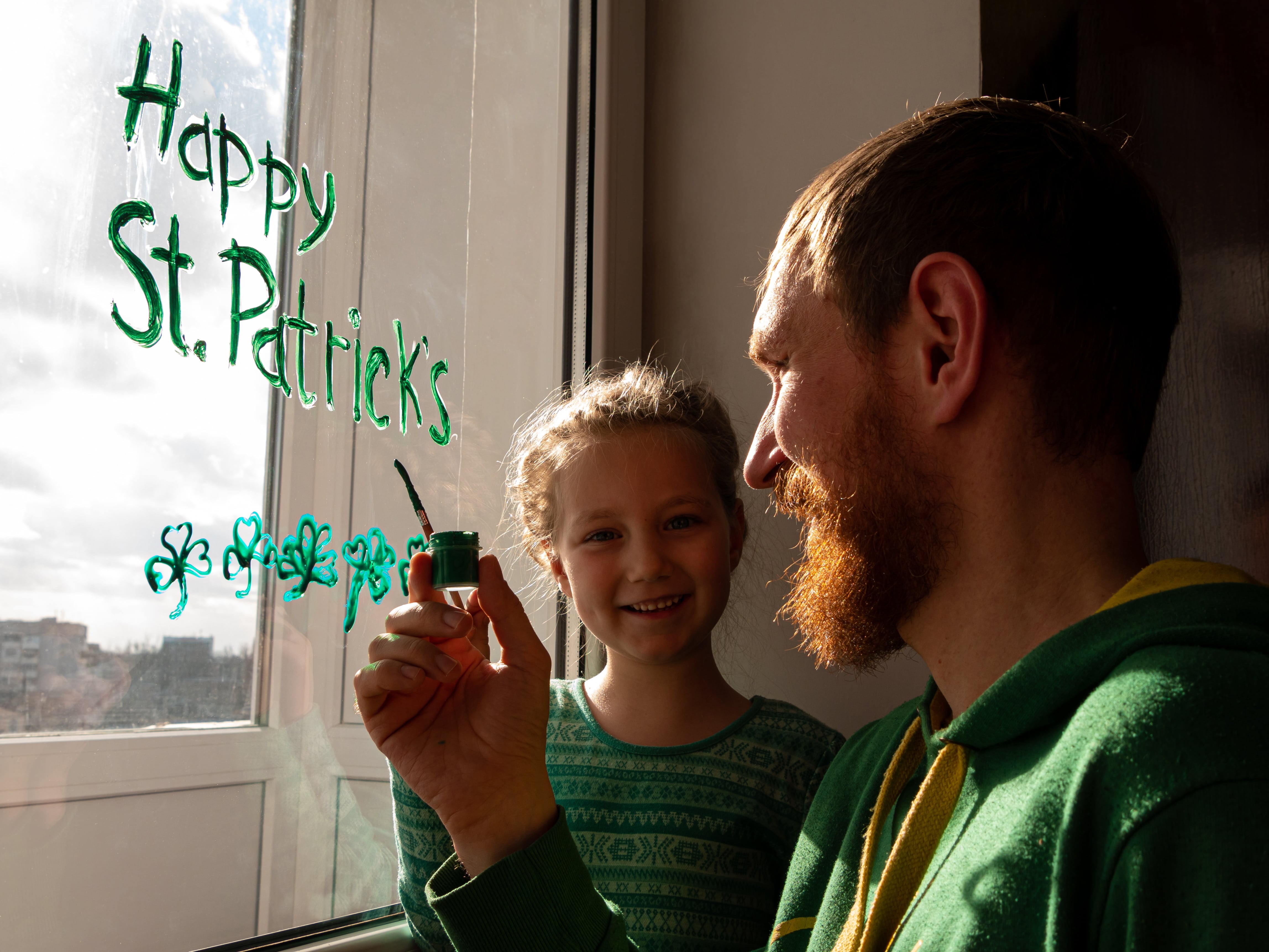 A father and his daughter enjoying St. Patrick's Day activities together. 